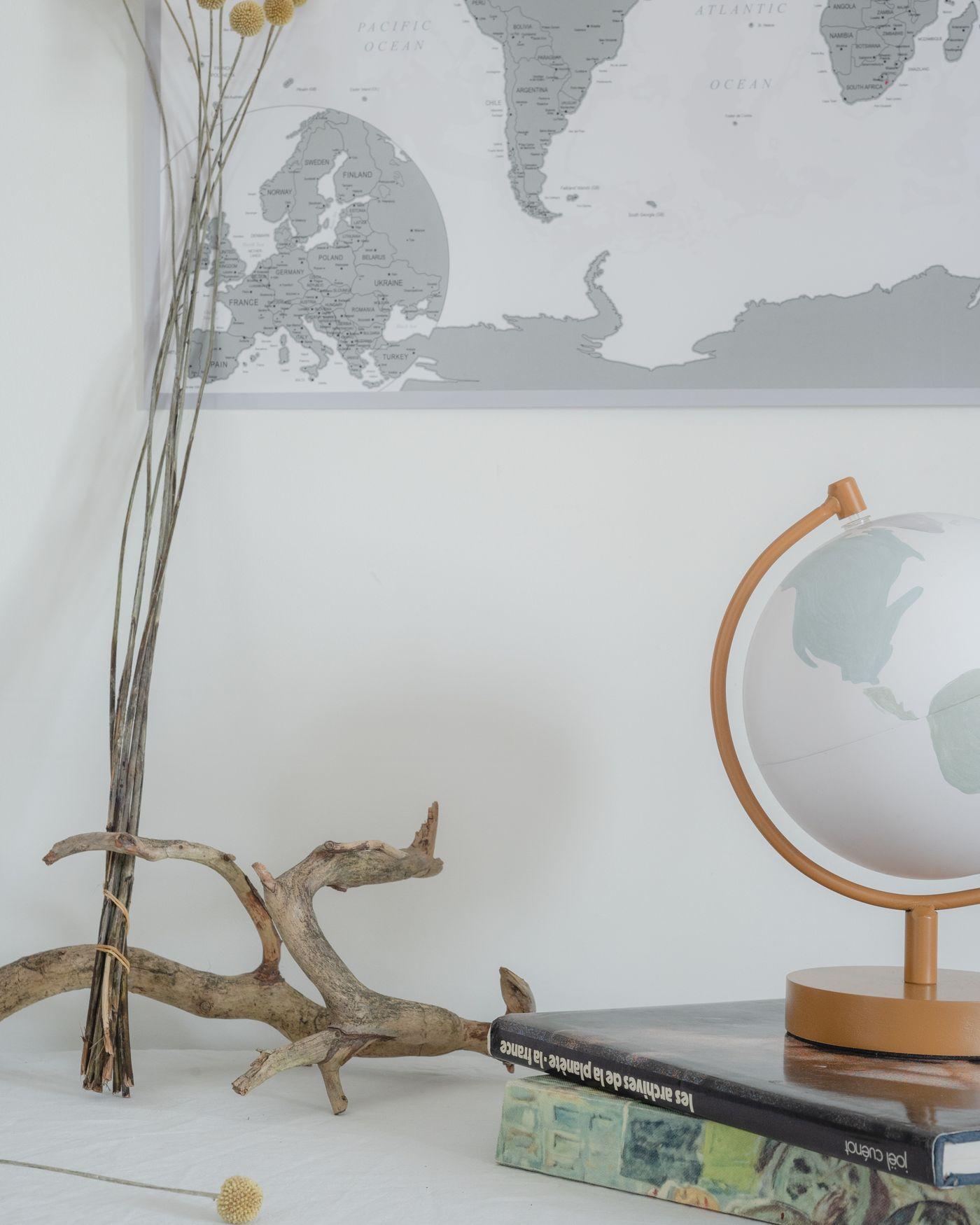 A desk globe and a world map beside a stack of books