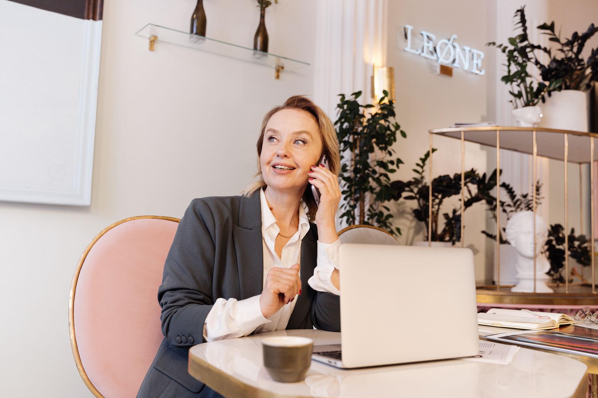 A sales lead on a call at her laptop, smiling
