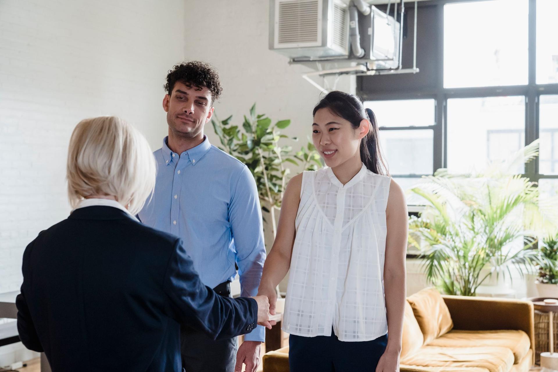 A local adviser welcomes a young couple into a bright apartment